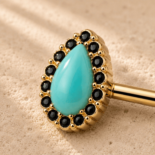 Close up of aqua enamel teardrop black surround on gold plated nipple bar, yellow gold zinc alloy enamel detail