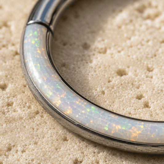 Opal seamless clicker ring on a sandy background