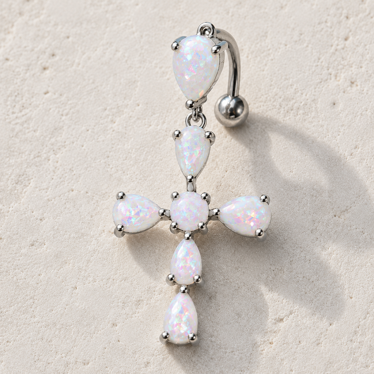 Close up of white synthetic opal cross prong set on navel ring, rainbow iridescent hues 316L stainless steel detail