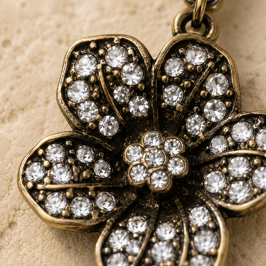 Close-up of a gold flower belly  button ring with crystal stones on a beige background