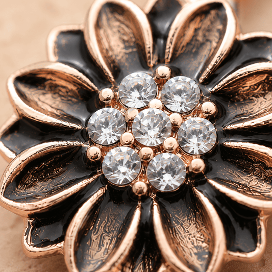 Close up of clear CZ cluster and sunflower metallic petals on antique rose gold navel ring, dark accent detail