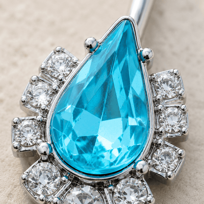 Close up of large aqua teardrop CZ surrounded by clear cubic zirconia on navel ring, 316L stainless steel detail