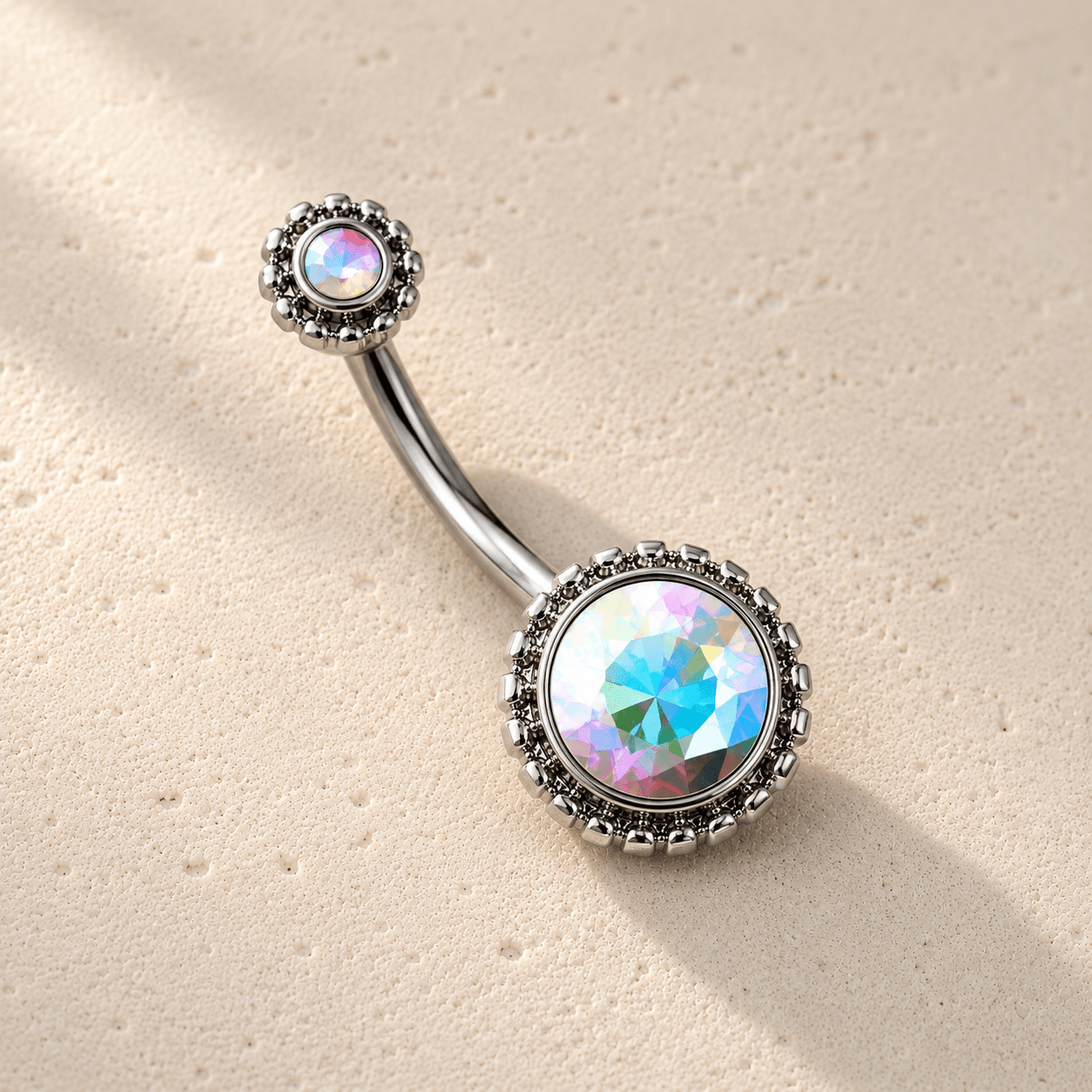 Navel ring with rainbow gemstone on a beige background