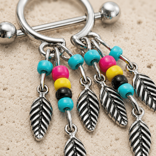 Close up of dream catcher design and multi-colored beaded feathers on nipple shield detail