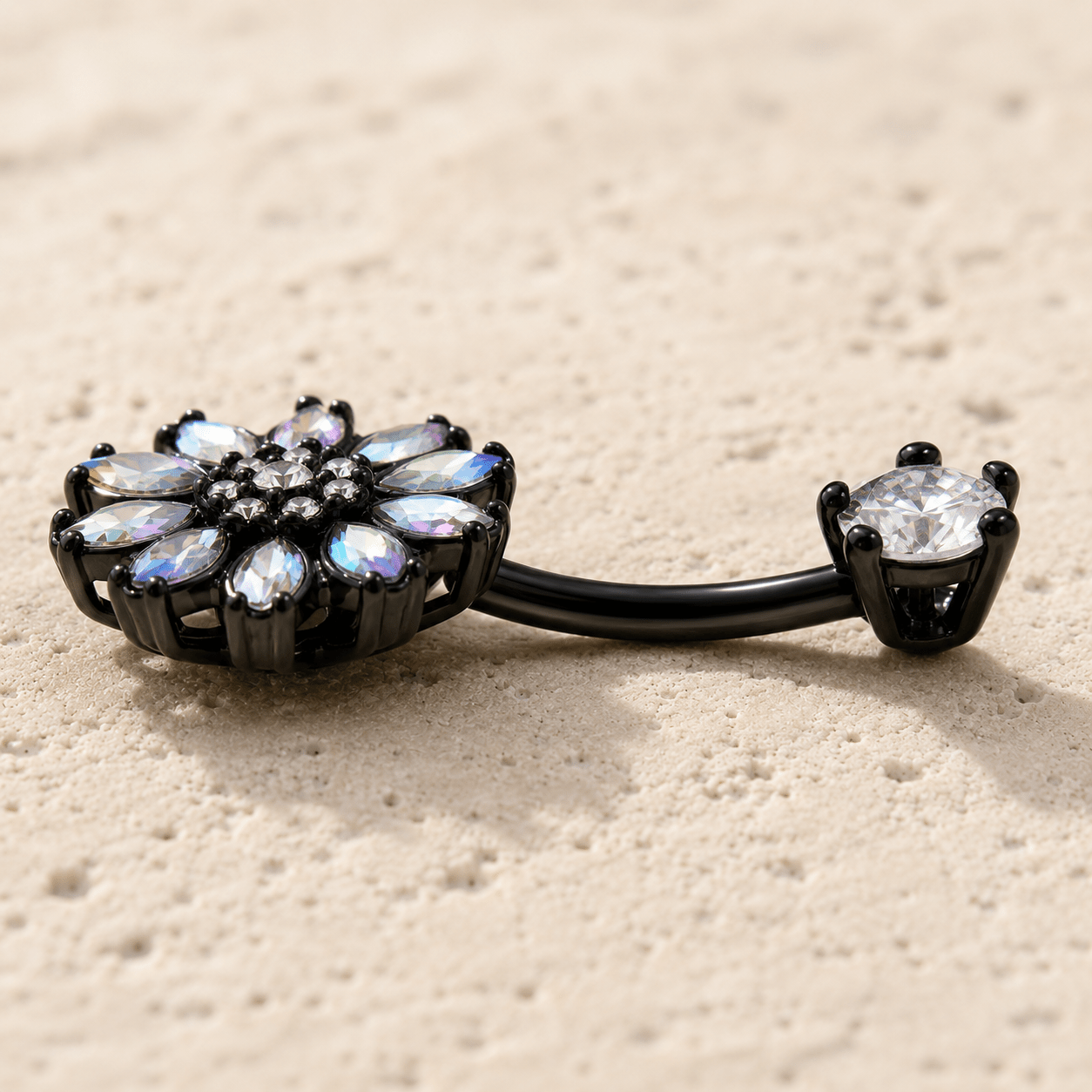 Black PVD Plated Aurora Borealis Flower on a beige surface
