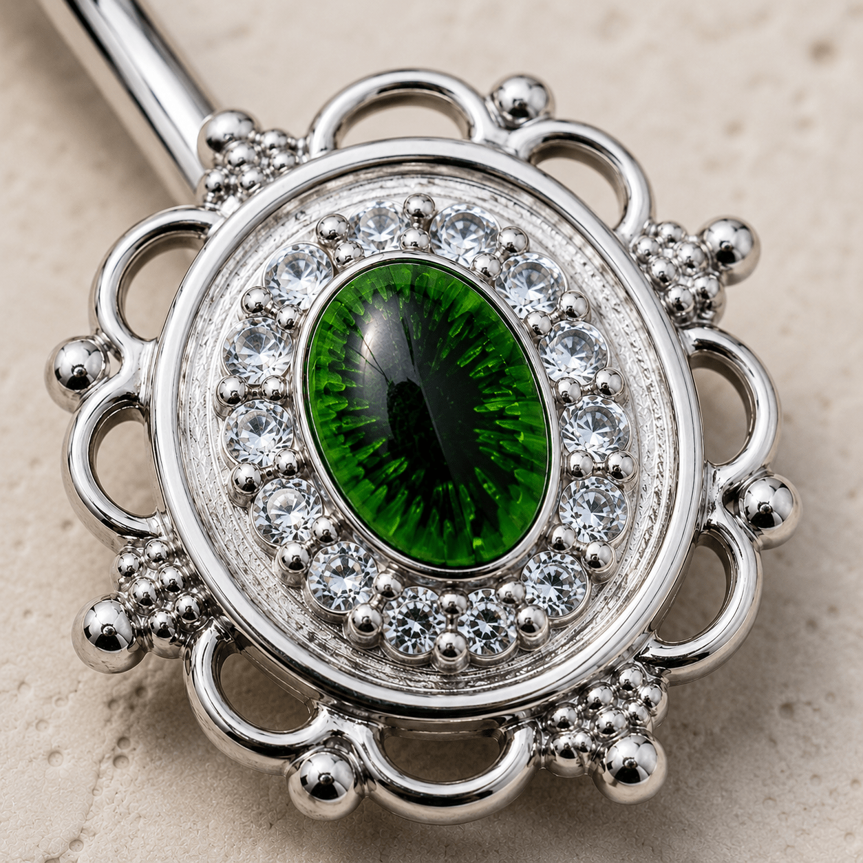 Close up of green eye design and cubic decoration on CZ mirror navel ring detail