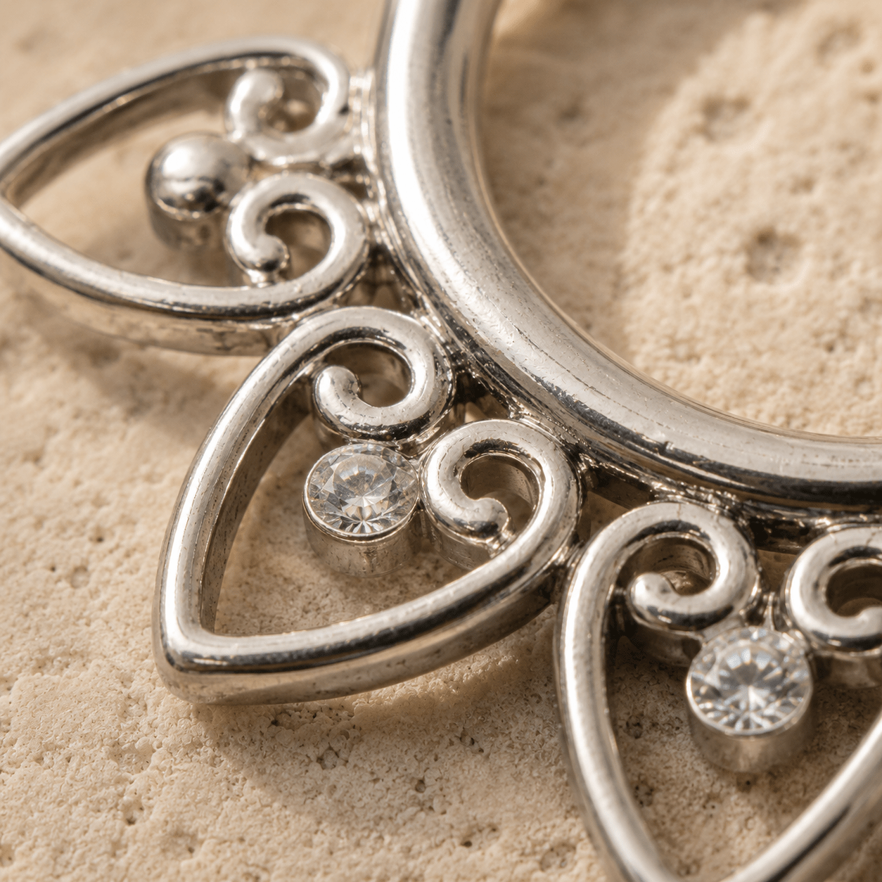 Close up of cubic zirconia gems on fake septum ring, dainty heart design, polished stainless steel detail