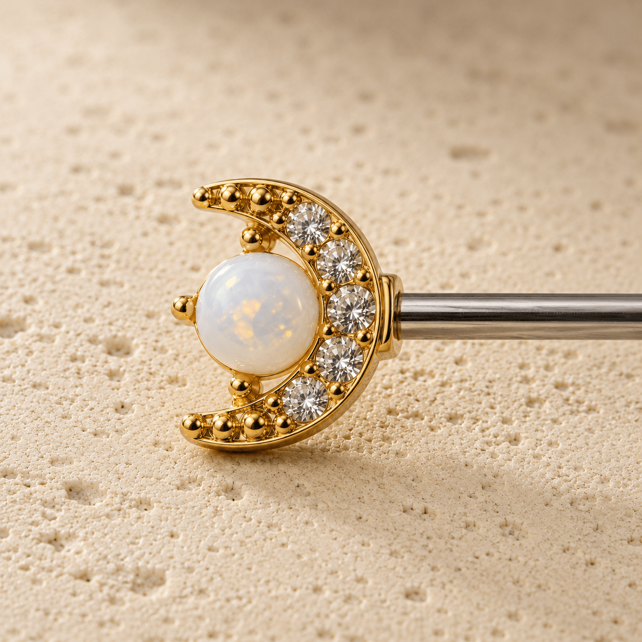 Close up of crescent moon CZ and white opal star on gold nipple bar, celestial detail