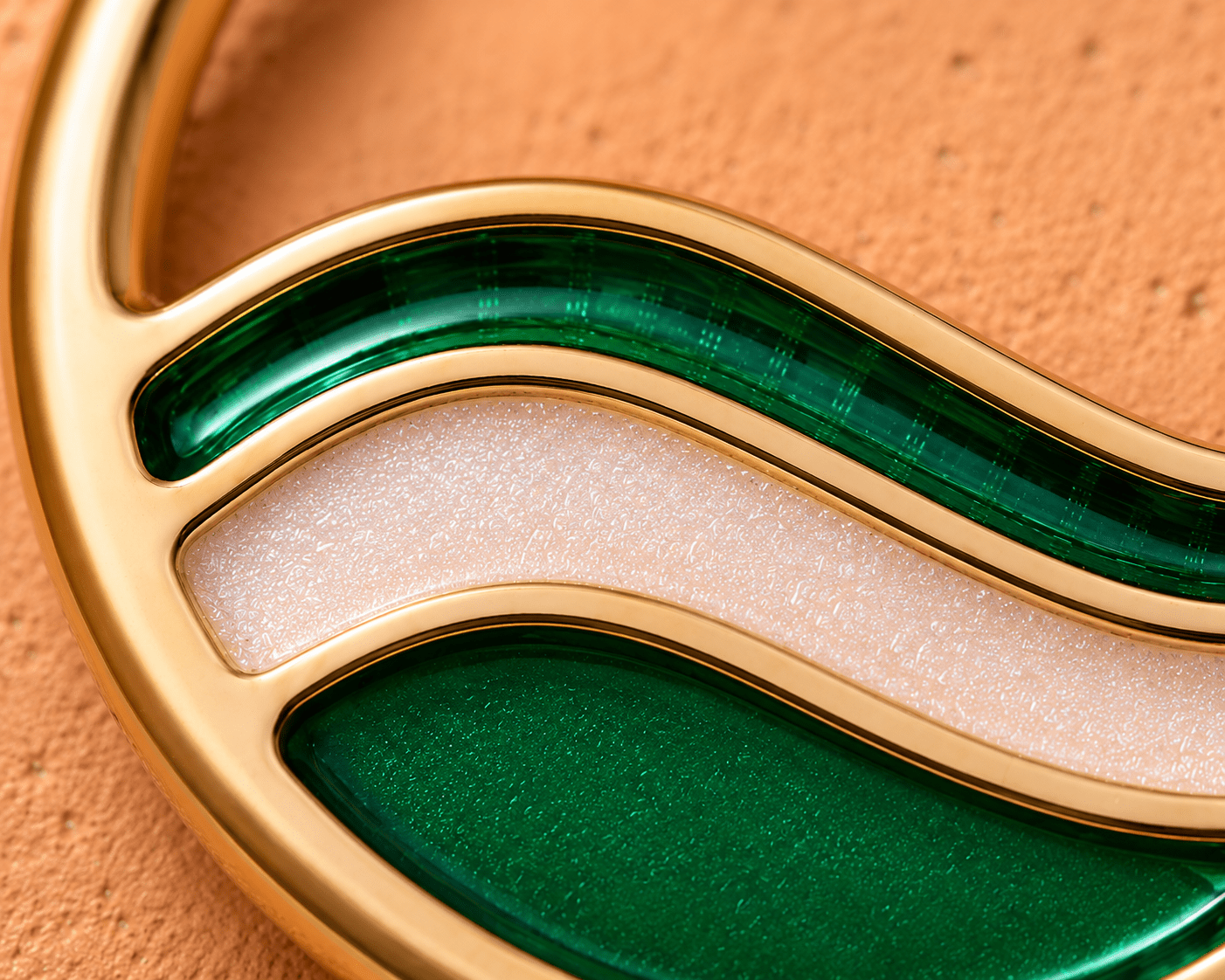 Close up of green and metallic white glitter enamel wave design on gold plated seamless ring detail
