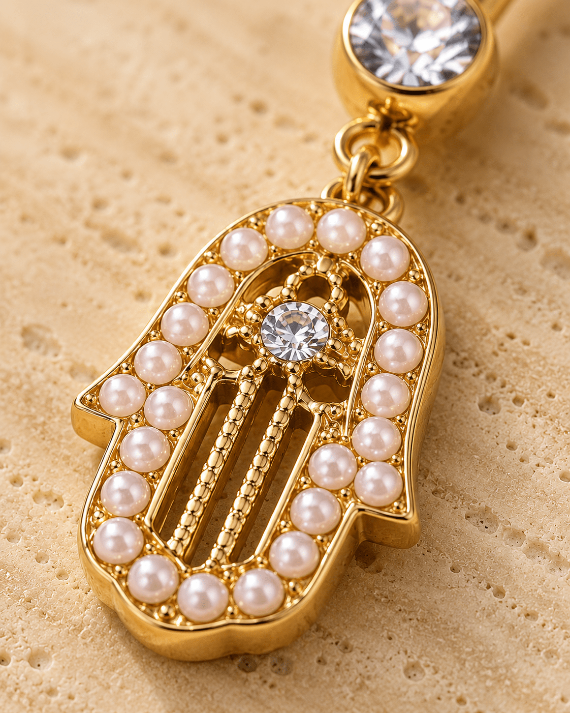 Close up of hamsa amulet pearl trim and CZ center on dangle navel ring detail