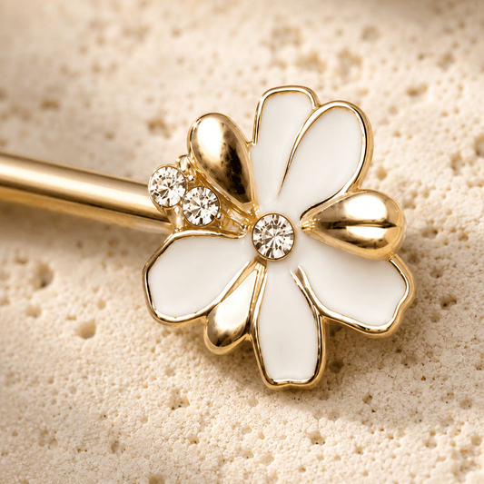 Close up of white enamel clear CZ flower on gold plated jeweled nipple bar, yellow gold plated zinc alloy detail