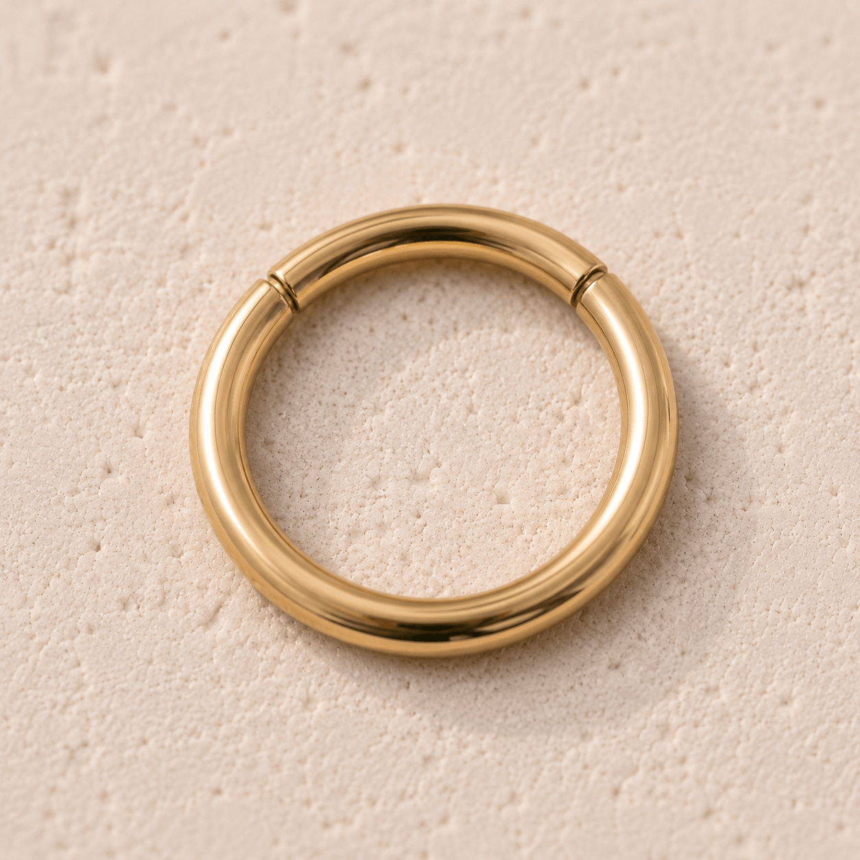 Close up of gold plated seamless clicker ring undetectable seam, yellow gold mirror polish surgical steel detail