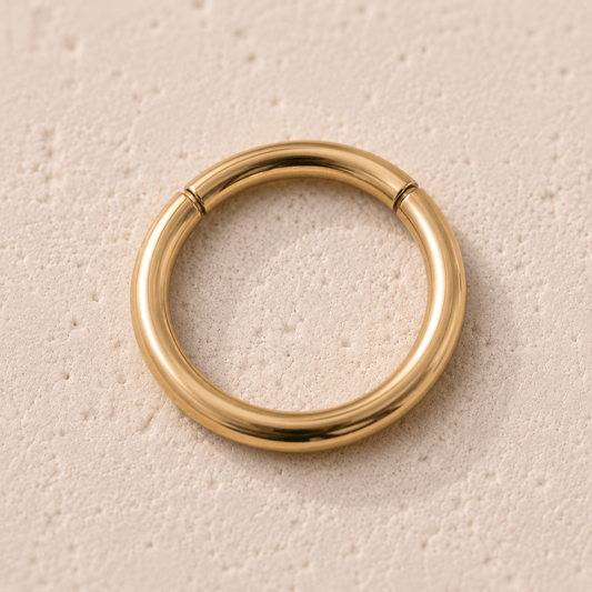 Close up of gold plated seamless clicker ring undetectable seam, yellow gold mirror polish surgical steel detail