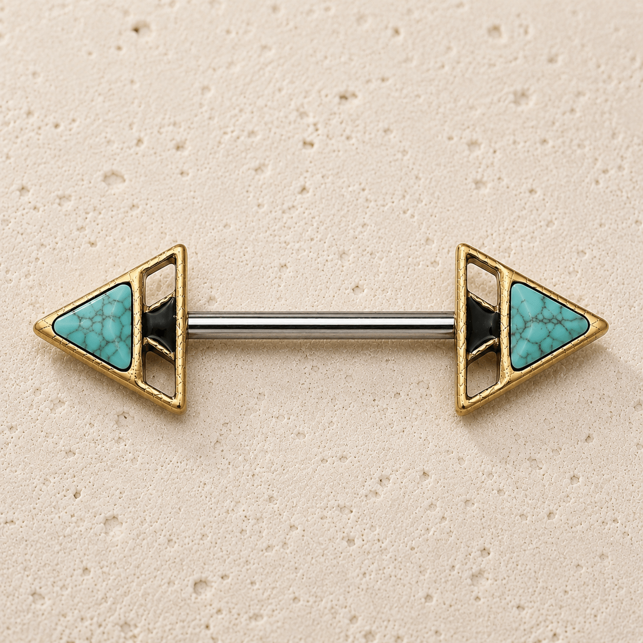 Pair of gold and turquoise nipple  bars on a beige background