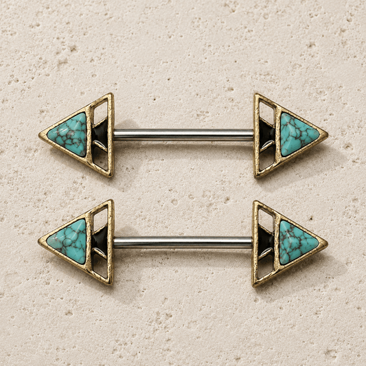 Pair of gold and turquoise triangle nipple barbell rings on a beige background