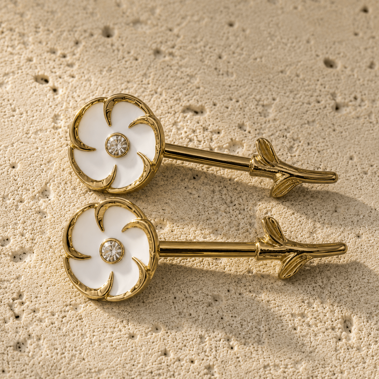 Styled aesthetic flat lay of gold plated white flower nipple bar pair, feminine floral yellow gold body jewelry