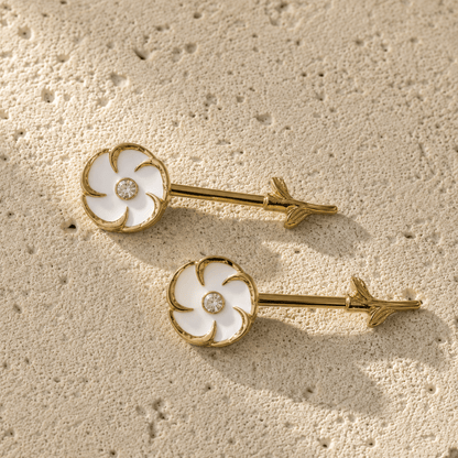 Styled aesthetic flat lay of gold plated white flower nipple bar pair, feminine floral yellow gold body jewelry