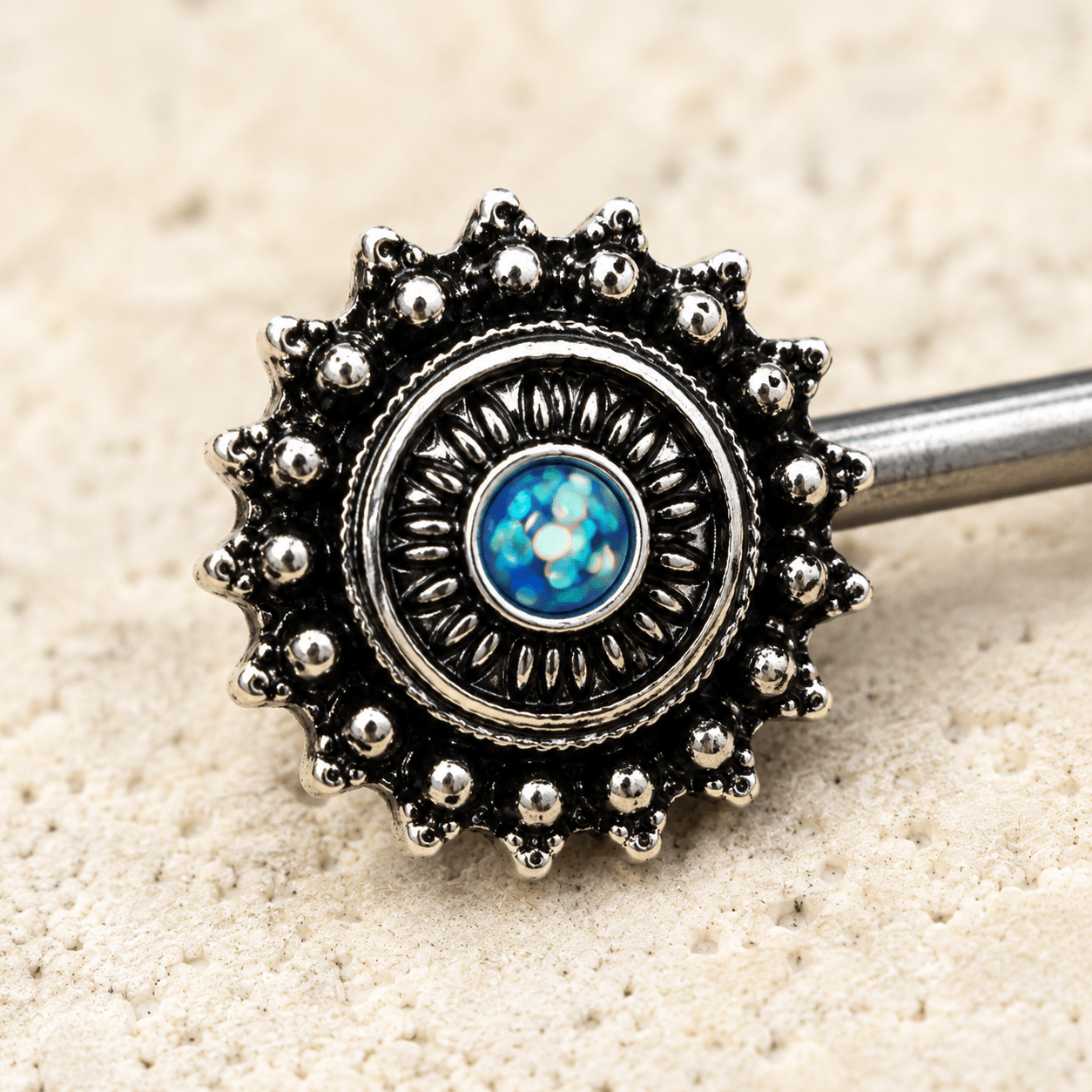 Close up of green synthetic opal center on ornate nipple bar, black plated zinc alloy detail

