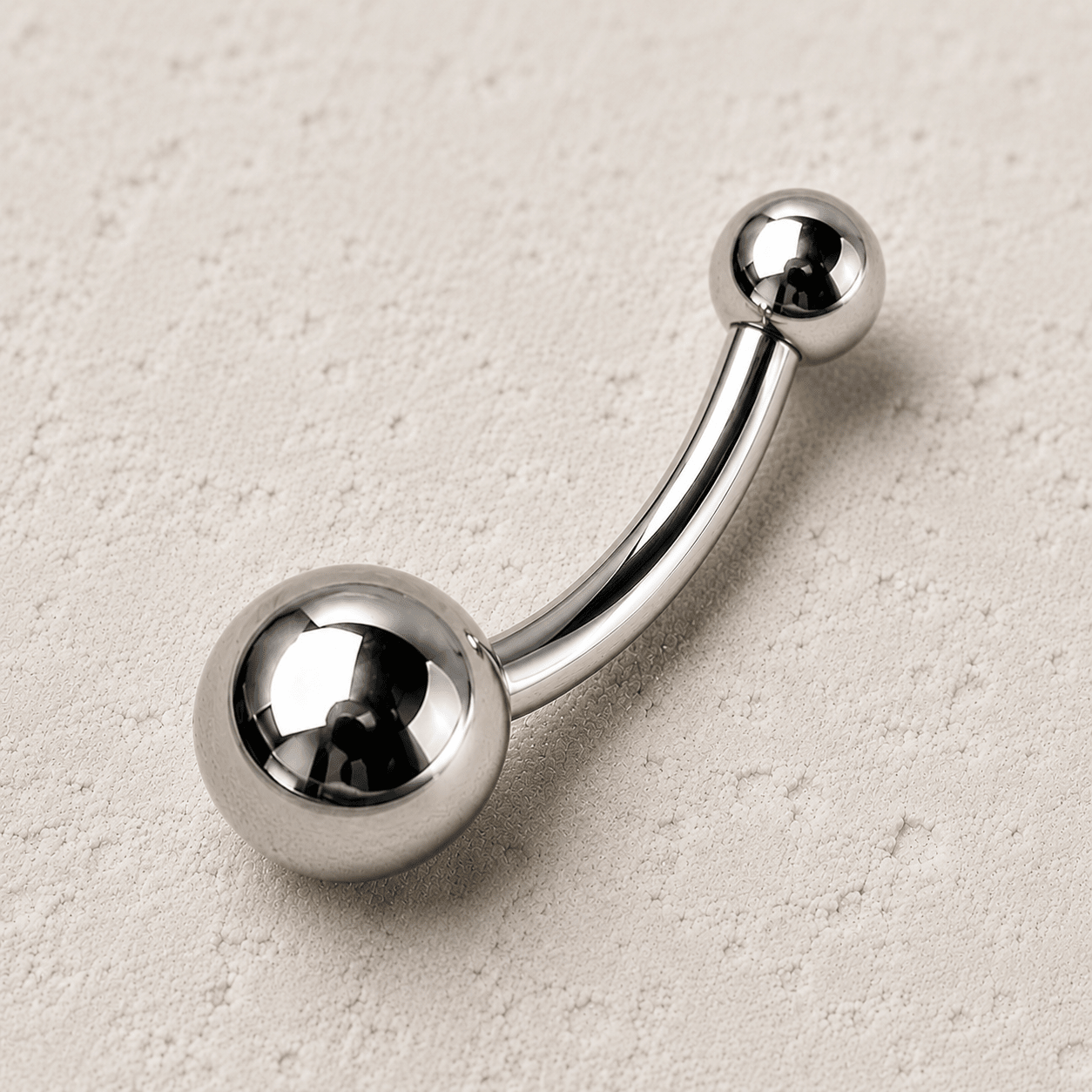 Close up of solid titanium balls on implant grade navel ring, Ti6AL4V ELI smaller top bigger bottom detail