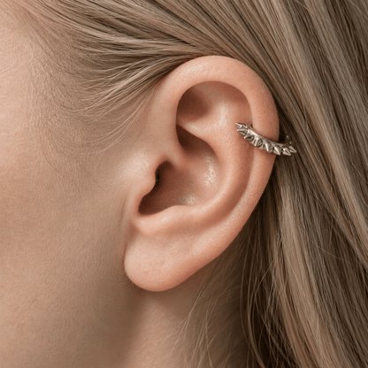 Close-up of an ear  cuff with a silver earring