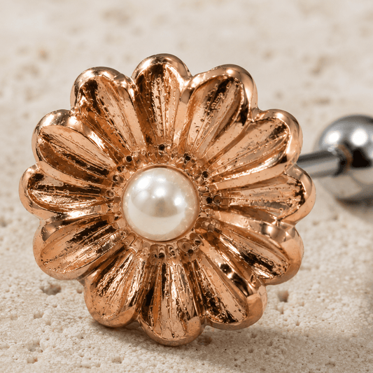 Close up of daisy flower design and white synthetic pearl center on rose gold cartilage earring