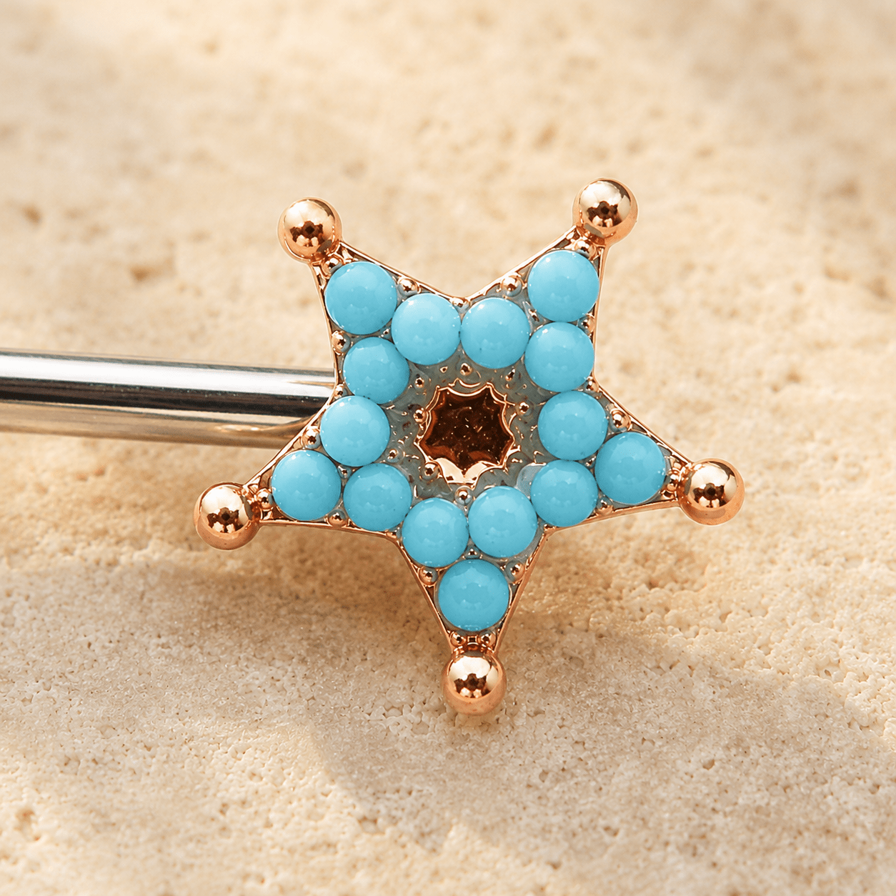 Close up of turquoise beads on rose gold plated moon and star nipple bar, gold plated zinc alloy celestial detail
