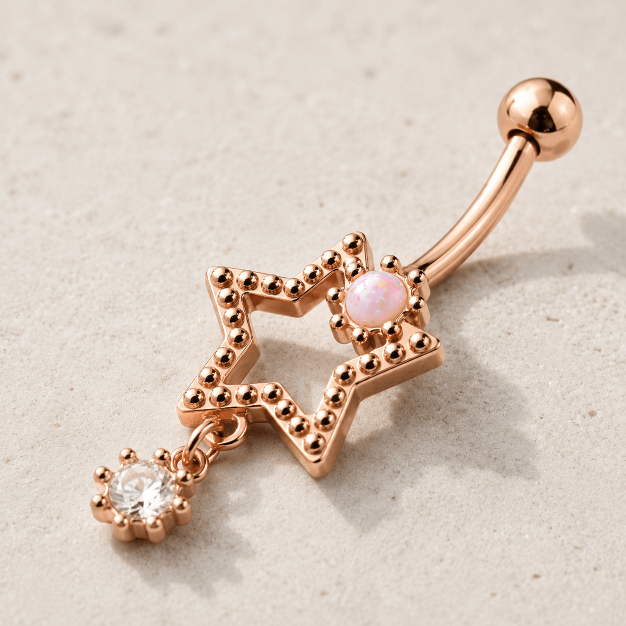 Side view of rose gold star drop navel ring, 14G externally threaded 316L stainless steel, dangling CZ star