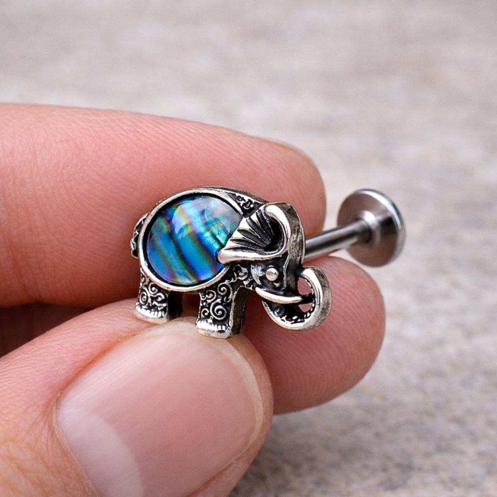 Hand holding abalone shell elephant labret stud, natural iridescent abalone 16G flat back Monroe jewelry