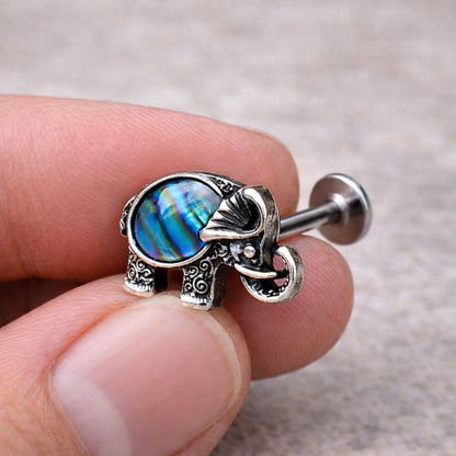 Hand holding abalone shell elephant labret stud, natural iridescent abalone 16G flat back Monroe jewelry