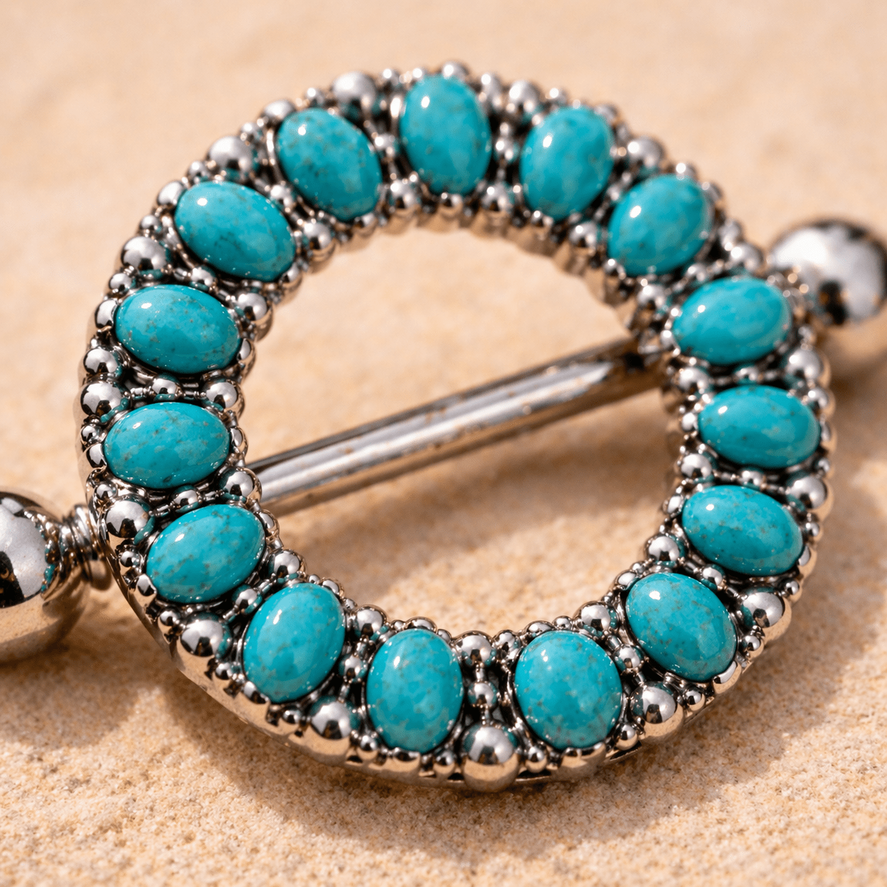 Close up of oval synthetic turquoise beads on antique nipple shield, black plated stainless steel detail