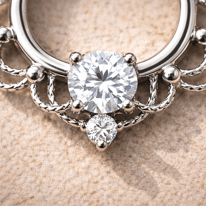 Silver ring with two round diamonds on a beige background