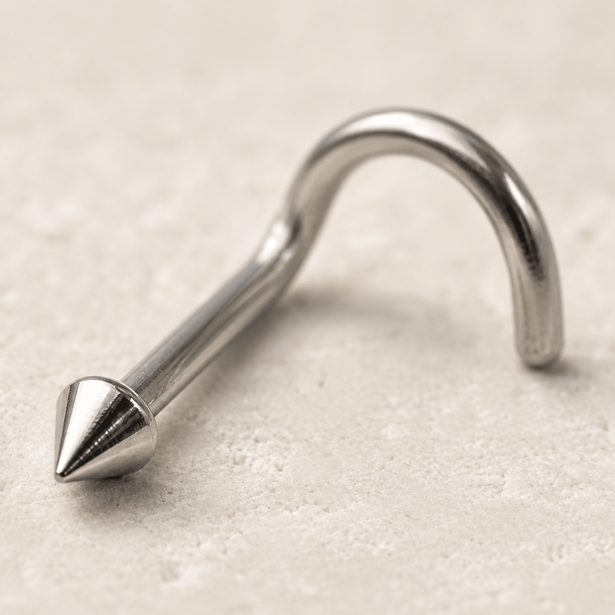 Close up of ball dome spike tops on stainless steel screw nose ring, mirror polished implant grade detail