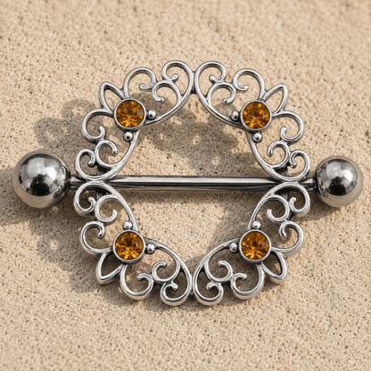 Close up of four round topaz CZ gems on ornate circular nipple shield, 316L stainless steel zinc alloy detail