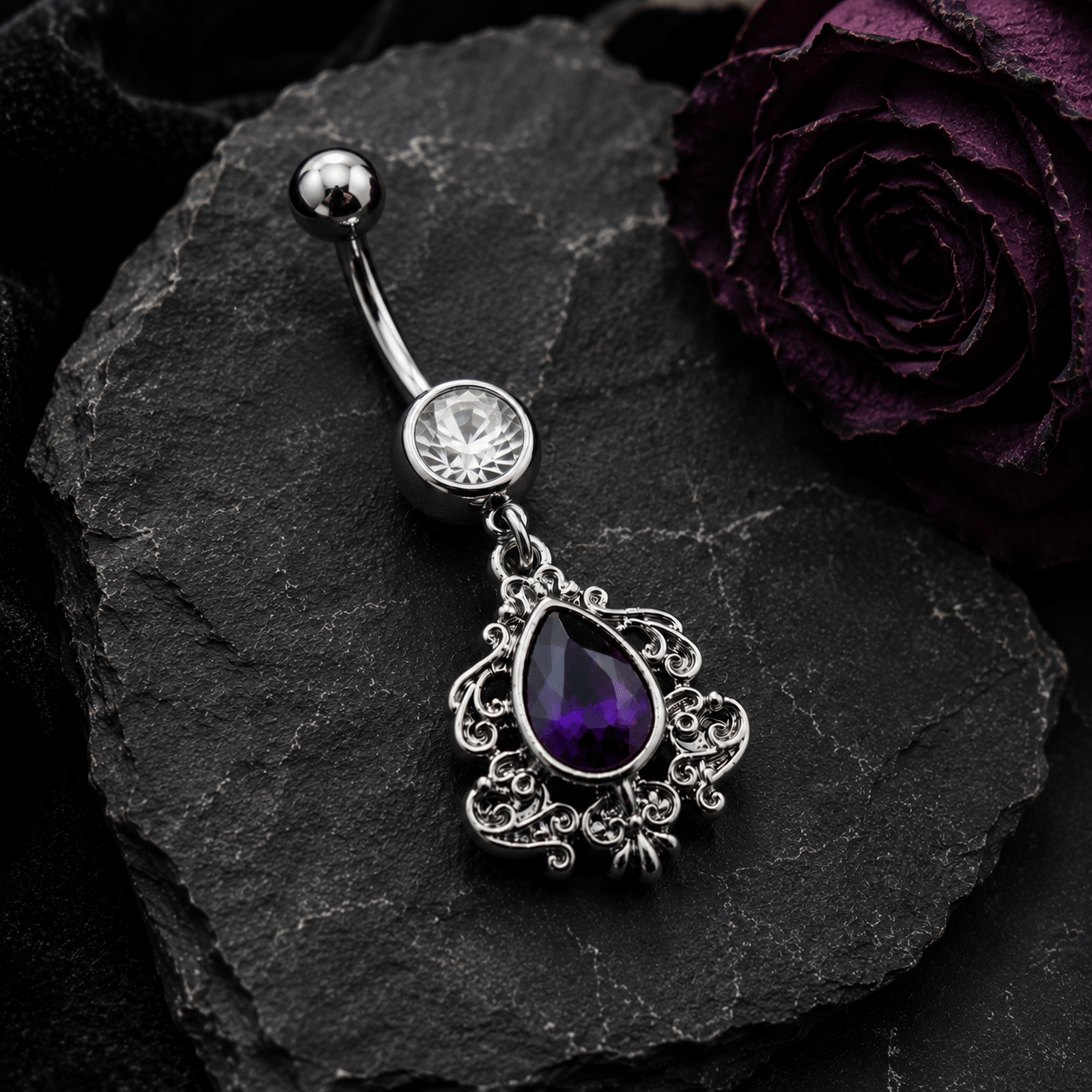 Styled flat lay of Victorian purple teardrop dangle navel ring, dramatic regal purple CZ belly jewelry
