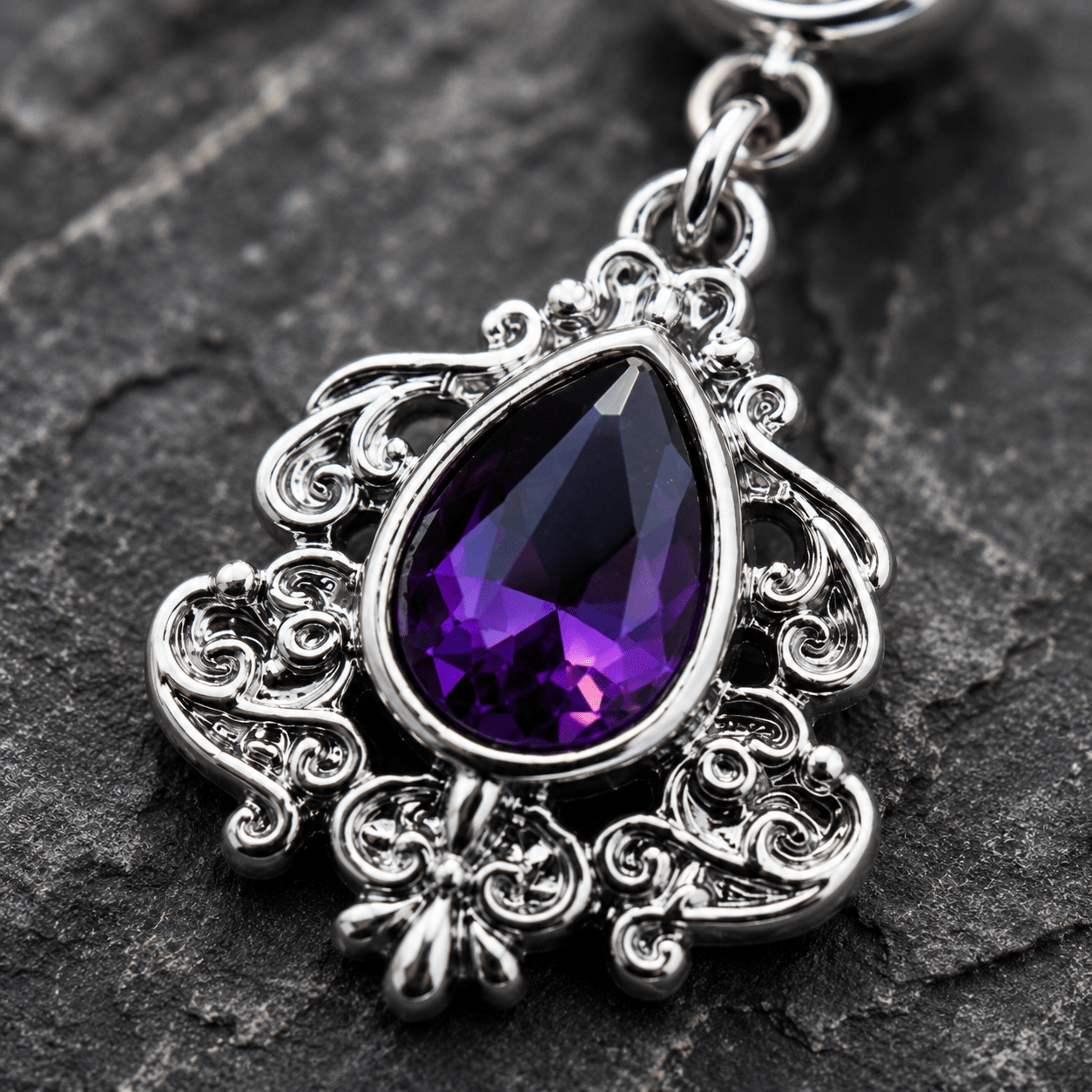 Close up of large purple teardrop CZ on ornate Victorian dangle navel ring, clear CZ bottom ball detail
